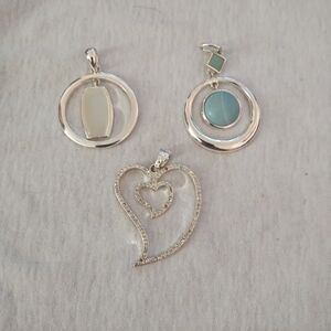 3 silver toned pendants